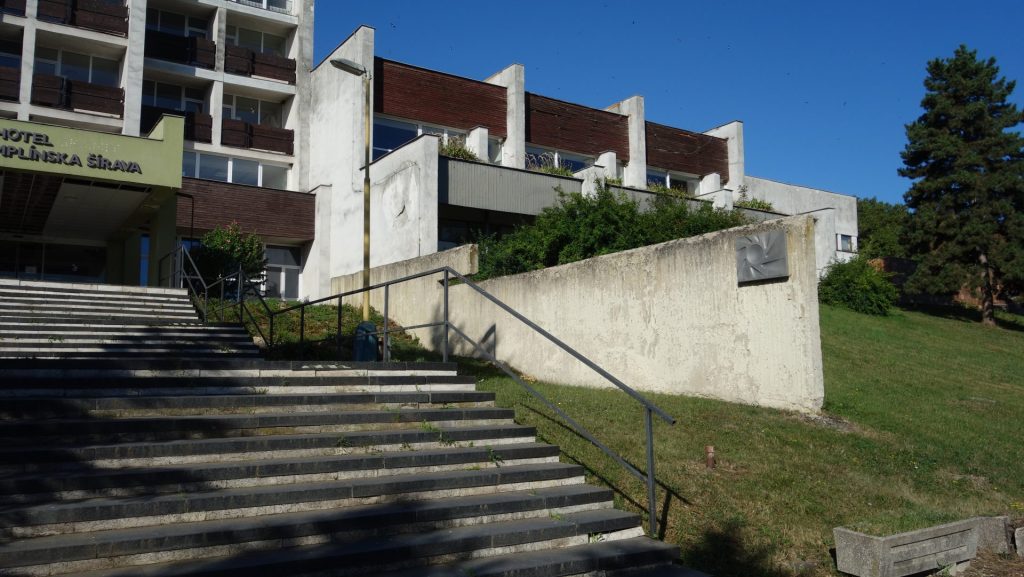 Hlavné nástupné schodisko s betónovou stenou a znakom zotavovne (soch. Peter Palatka, osadené 1988), 2025. Foto: Monika Kicová, archív IMA.